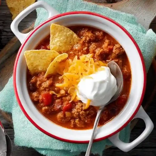 Gluten-free Halloween snacks arranged on a black tray with spooky decorations, including mummy-shaped appetizers and jack-o'-lantern veggies, ideal for a festive and dietary-restriction-friendly party